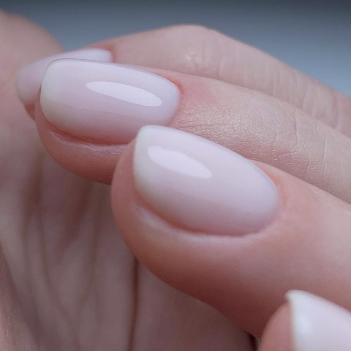 Close-up van glanzende, melkwitte BIAB-nagels